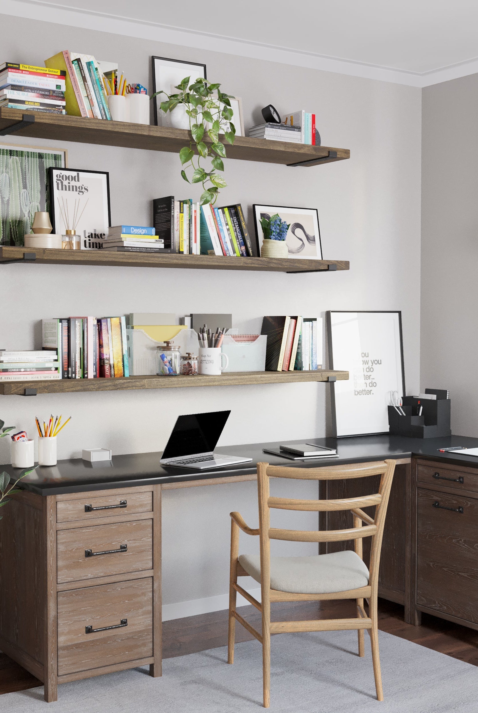 A functional home office setup featuring three wall mounted shelves in custom walnut finish adorned with books and decor. Below, an L-shaped desk with storage drawers, a wooden chair, and a potted plant create a balanced, productive environment.