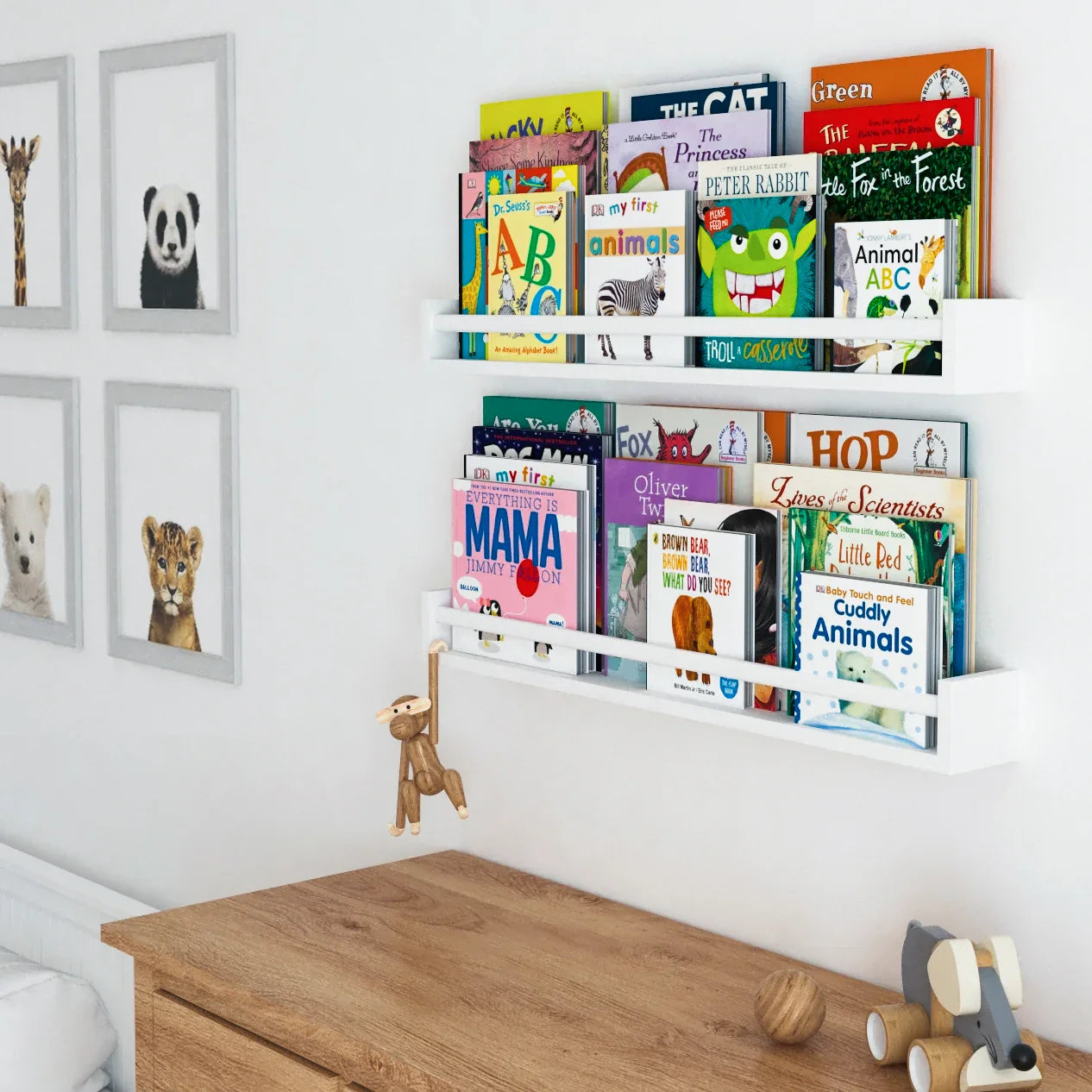 Two white wall-mounted cute bookshelves. These  nursery shelves for kids are designed specifically for children's rooms, with a front lip that keeps books securely in place while allowing the covers to be fully visible.