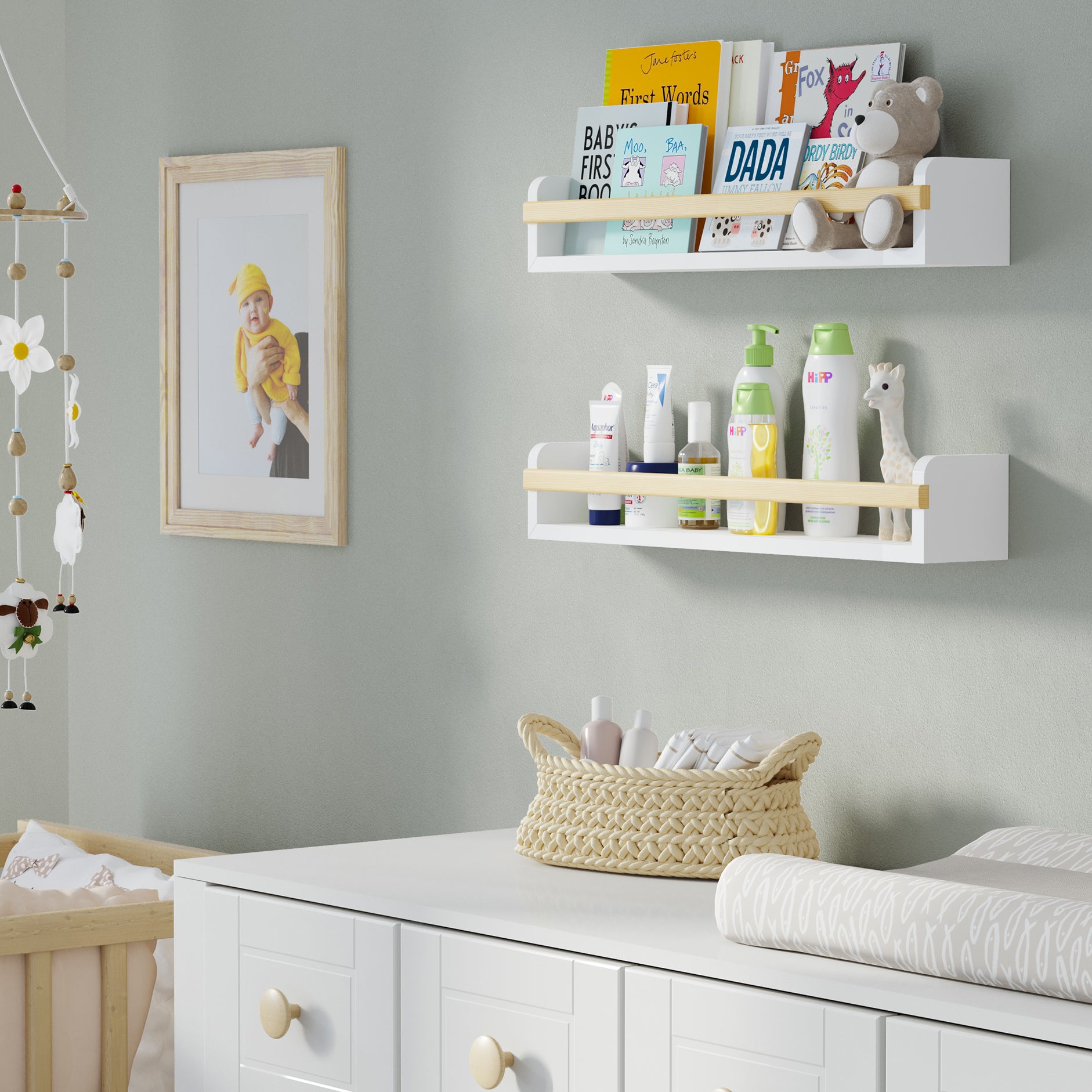 Two white shelves for nursery in a nursery, one holding children's books and the other baby care products. Mounted above a white dresser with a woven basket, creating an organized and cozy space for a baby.