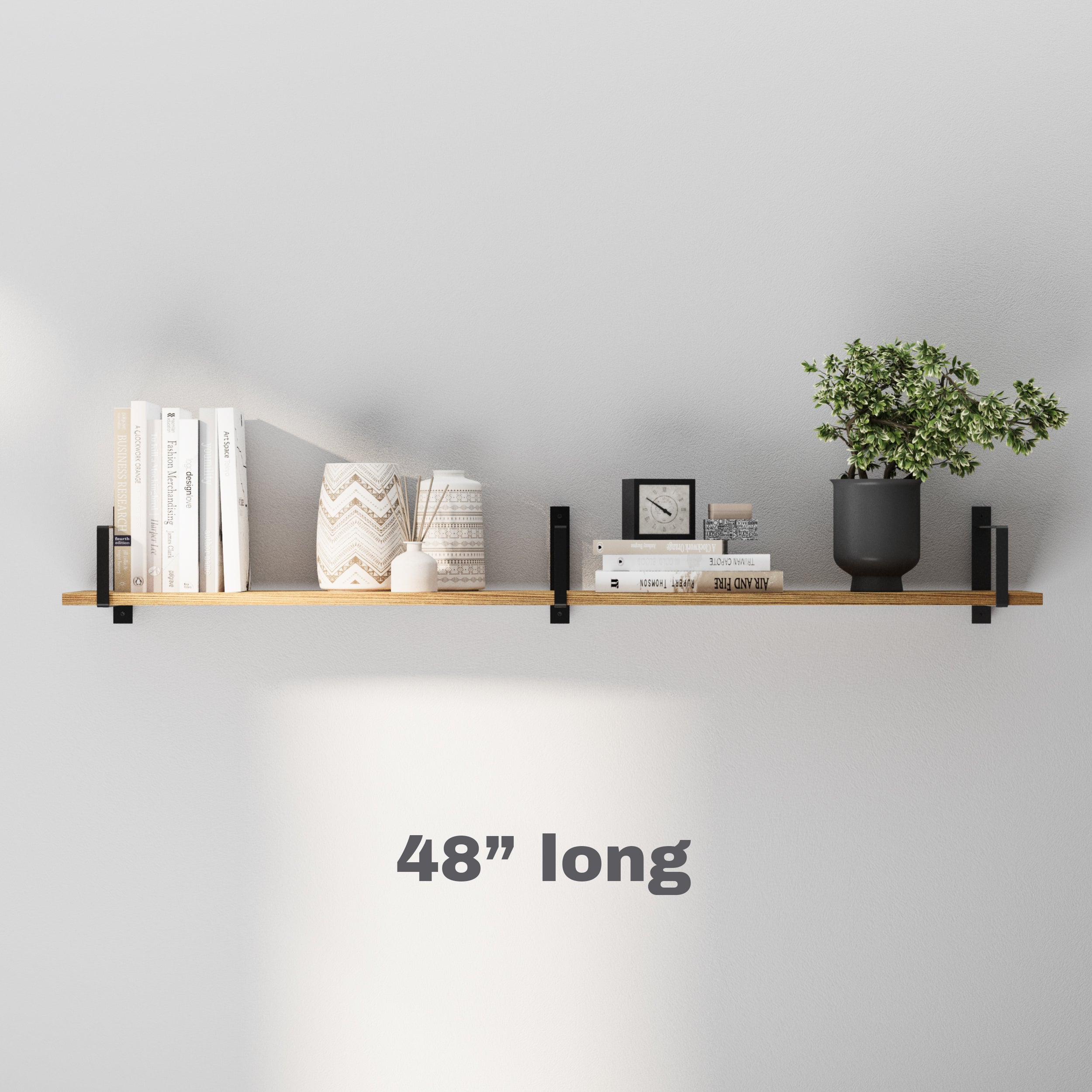 A 48-inch-long farmhouse display shelf mounted on a gray wall, featuring a minimalist arrangement of books, a plant, a clock, and decorative accents, with soft lighting enhancing the aesthetic appeal.