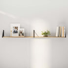 Farmhouse floating shelf setup with black triangle brackets, styled with neutral-toned books, geometric art, and ceramic vases for a warm modern vibe.