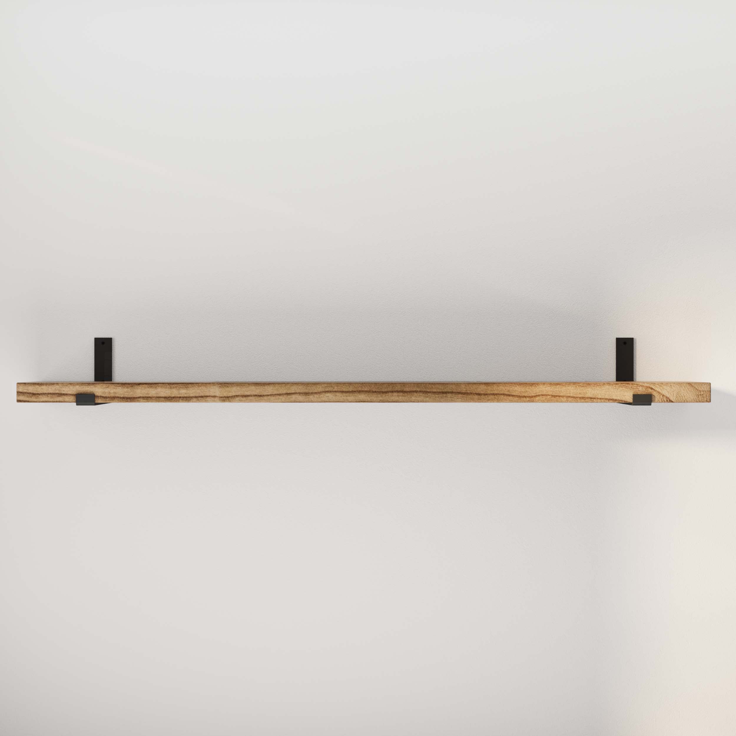 Empty 60'' wooden floating shelf with black brackets on a white wall.