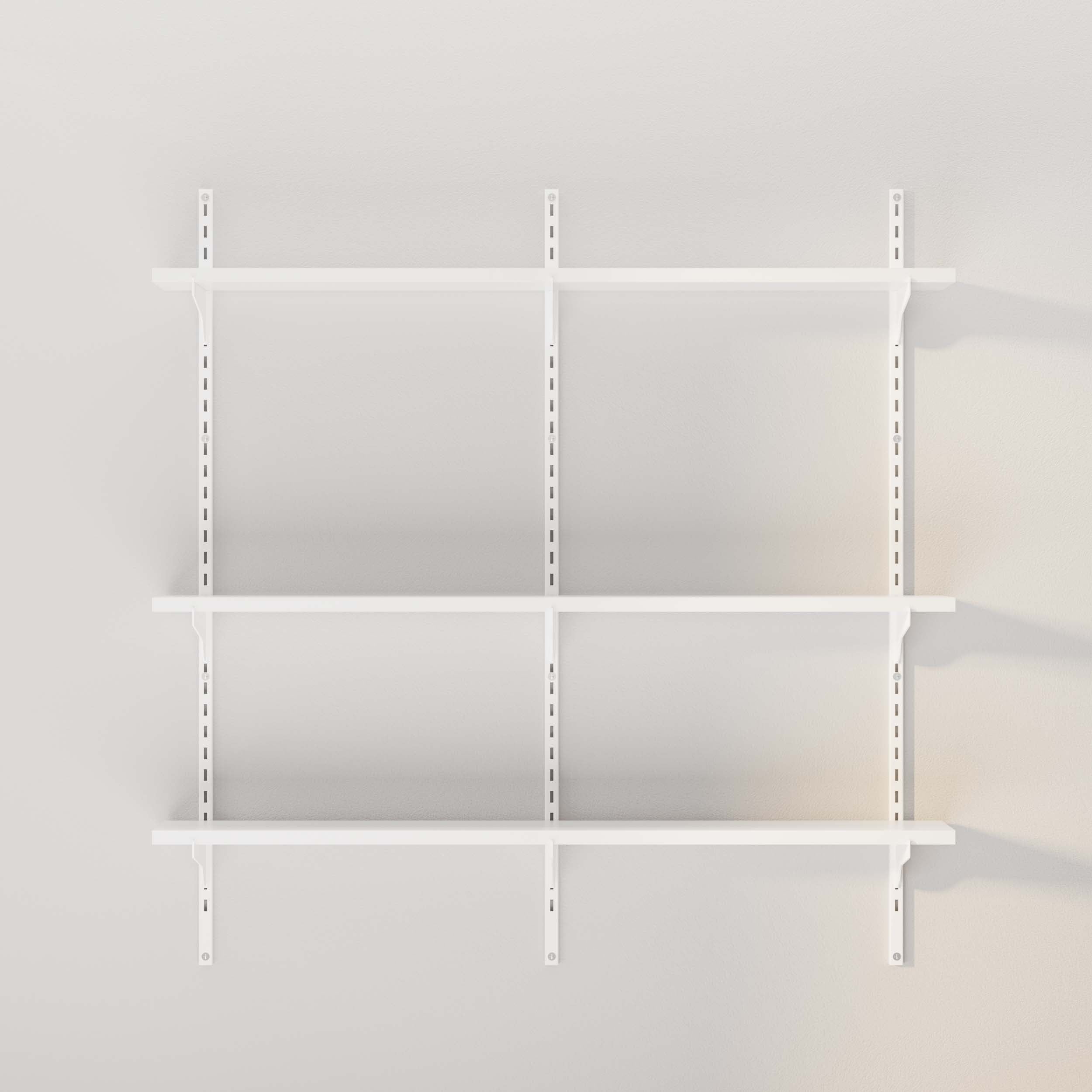 A plain view of empty white shelves with metal brackets on a light wall.