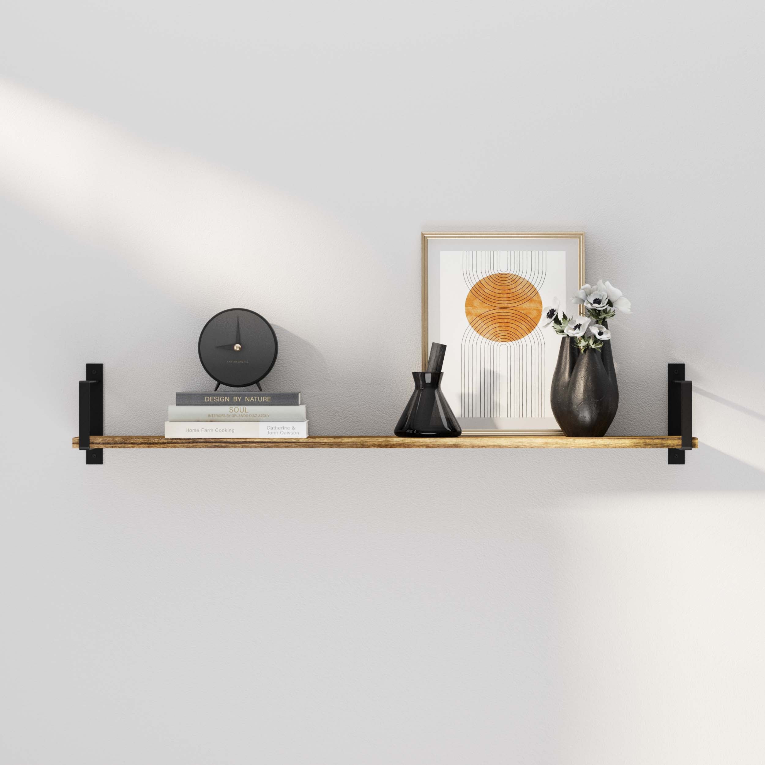A clean, modern wall bookshelf styled with black brackets, showcasing a small clock, black vases, books, and a framed art print — ideal for entryways, living rooms, or modern home offices.