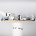 A 72” long floating shelf for storage in a warm wood finish, mounted with black metal brackets. Styled with minimal books, candles, and ceramic decor, perfect for adding functional elegance to any room.