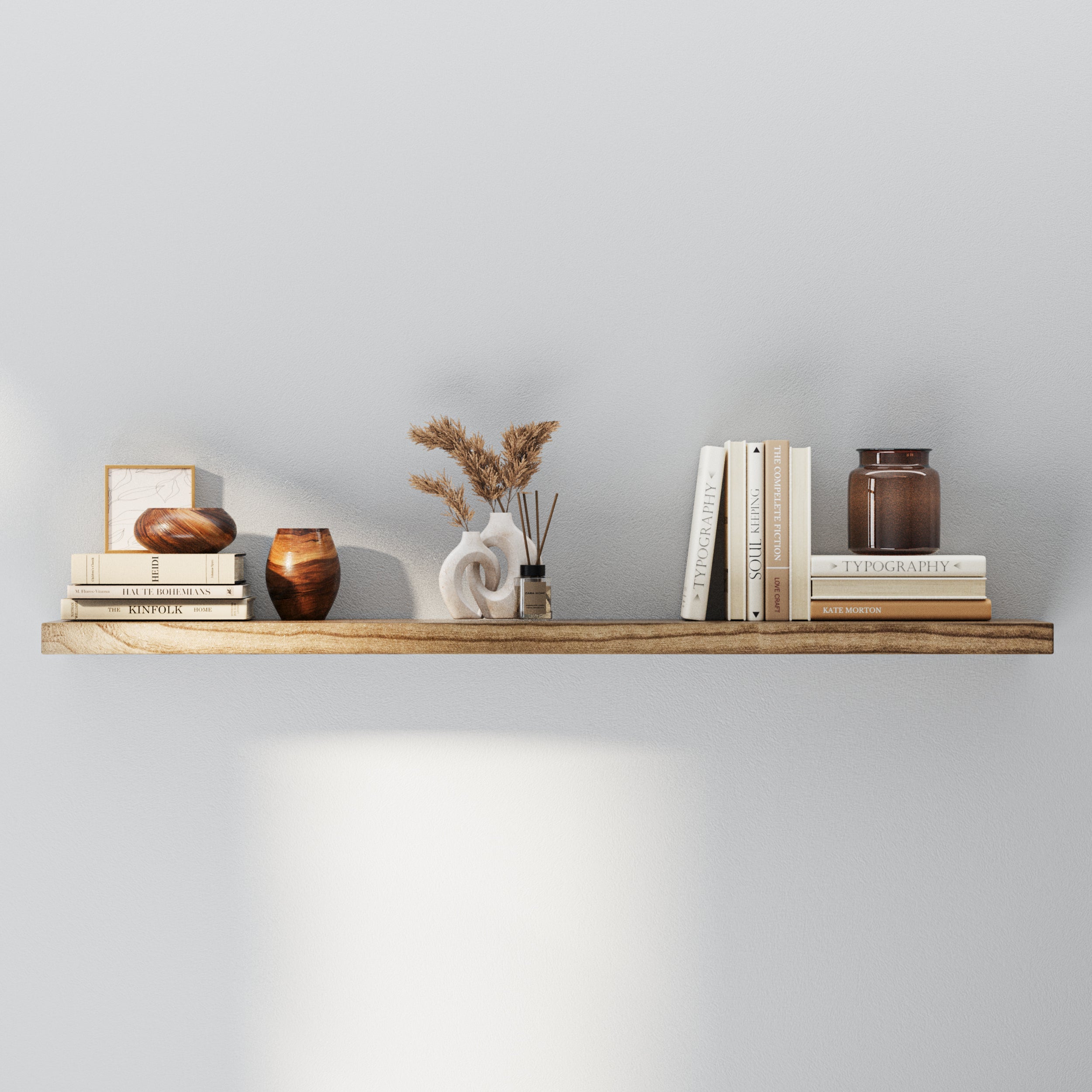 A thick hidden bracket shelf in a rustic wood tone is styled with neutral-toned books, sculptural vases, and dried florals in a ceramic vase. A minimal setup that combines texture and simplicity for a modern aesthetic.