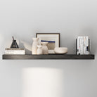 A floating shelf in a rich ebony finish, decorated with neutral-toned vases, a framed print, and books. Minimalist yet warm design ideal for modern living spaces.