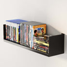 The sturdy black floating shelf holds multiple DVDs, showcasing its capacity and practical use for organizing your media collection neatly.