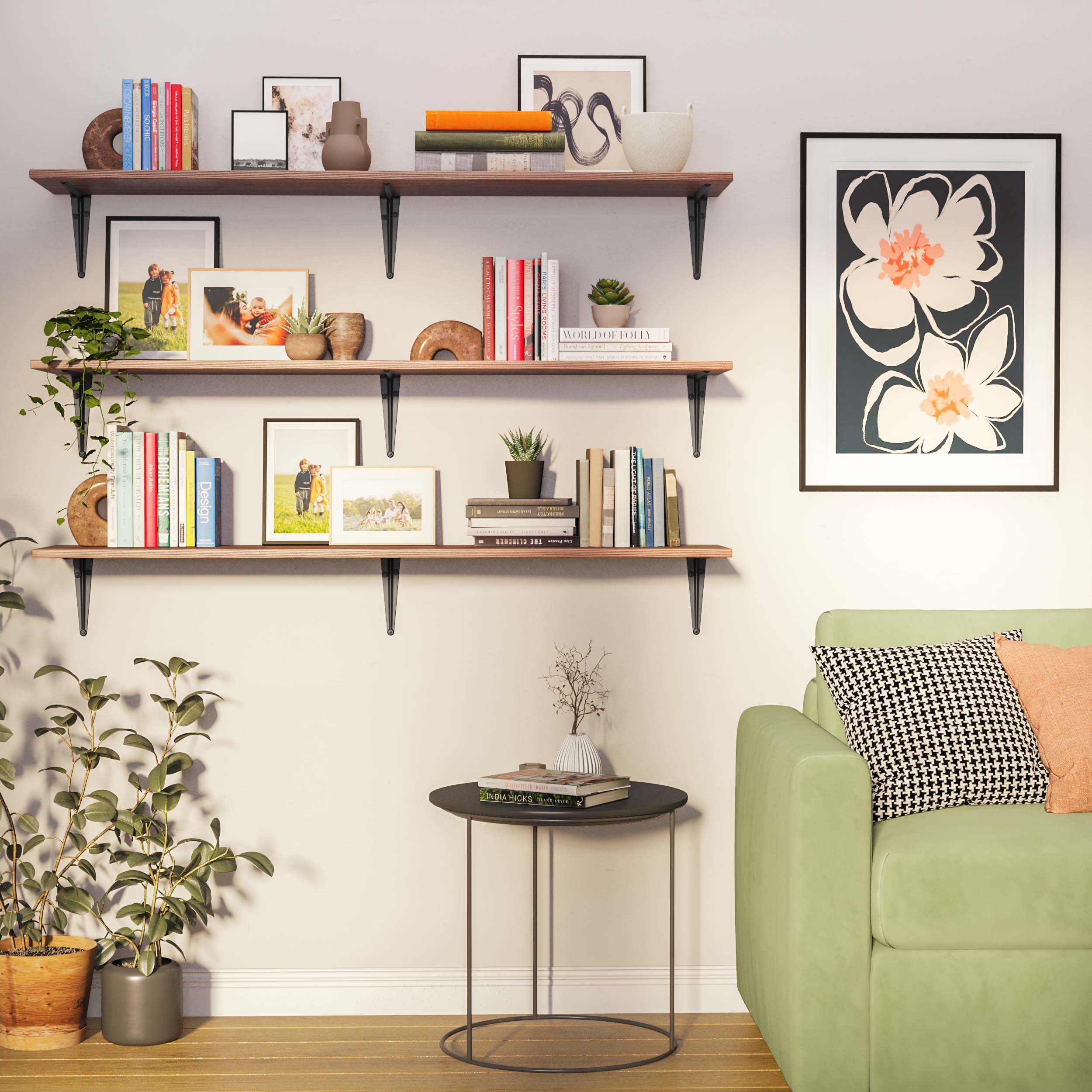 Three-tier long farmhouse shelf arrangement with dark heavy duty brackets supporting richly grained wood. Styled with books, art, and small plants, complementing the green couch and soft color palette of the room.