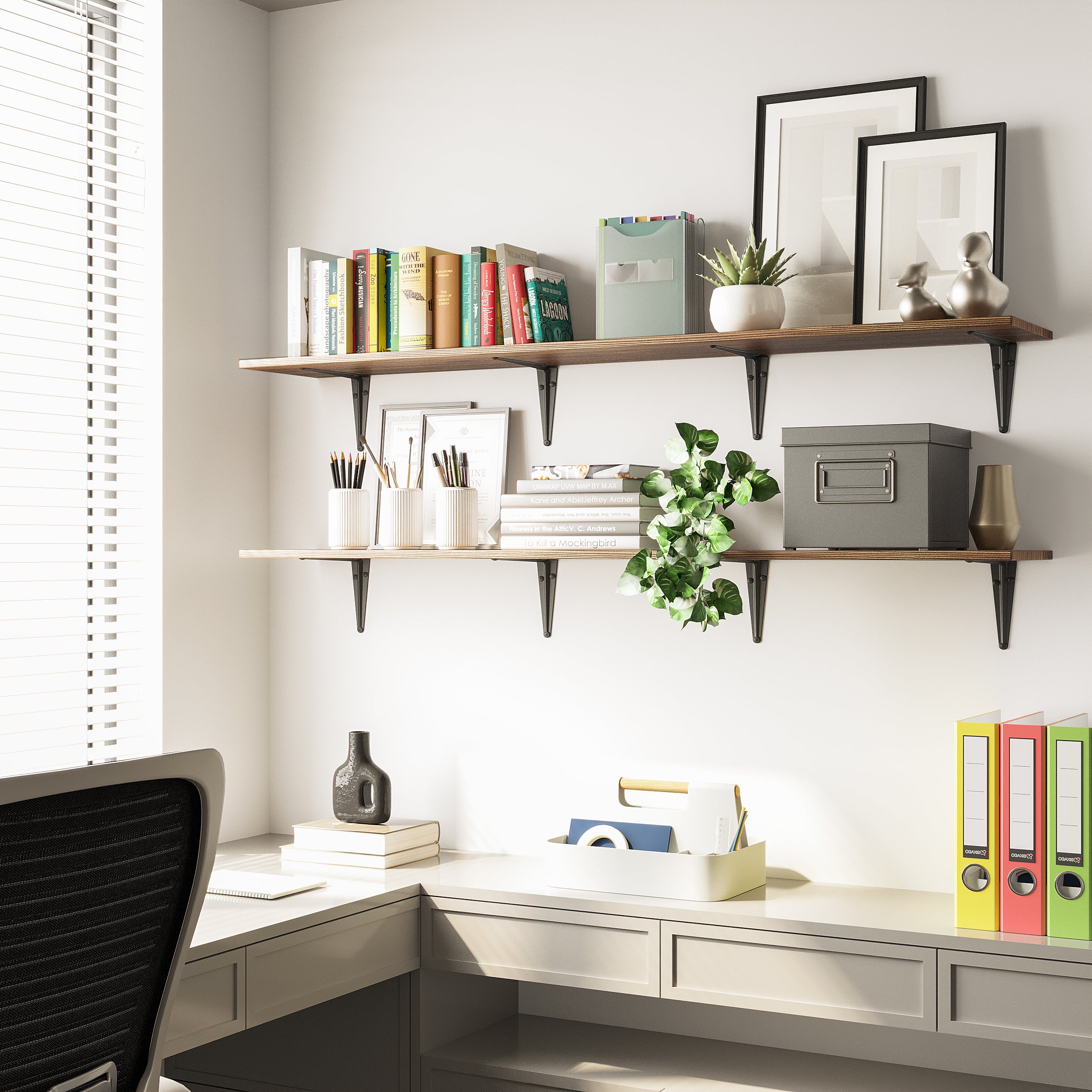 A home office with two-tier dark wood office shelves supported by black brackets. Decorated with books, plants, and file boxes above a white built-in desk, this space blends storage and style.