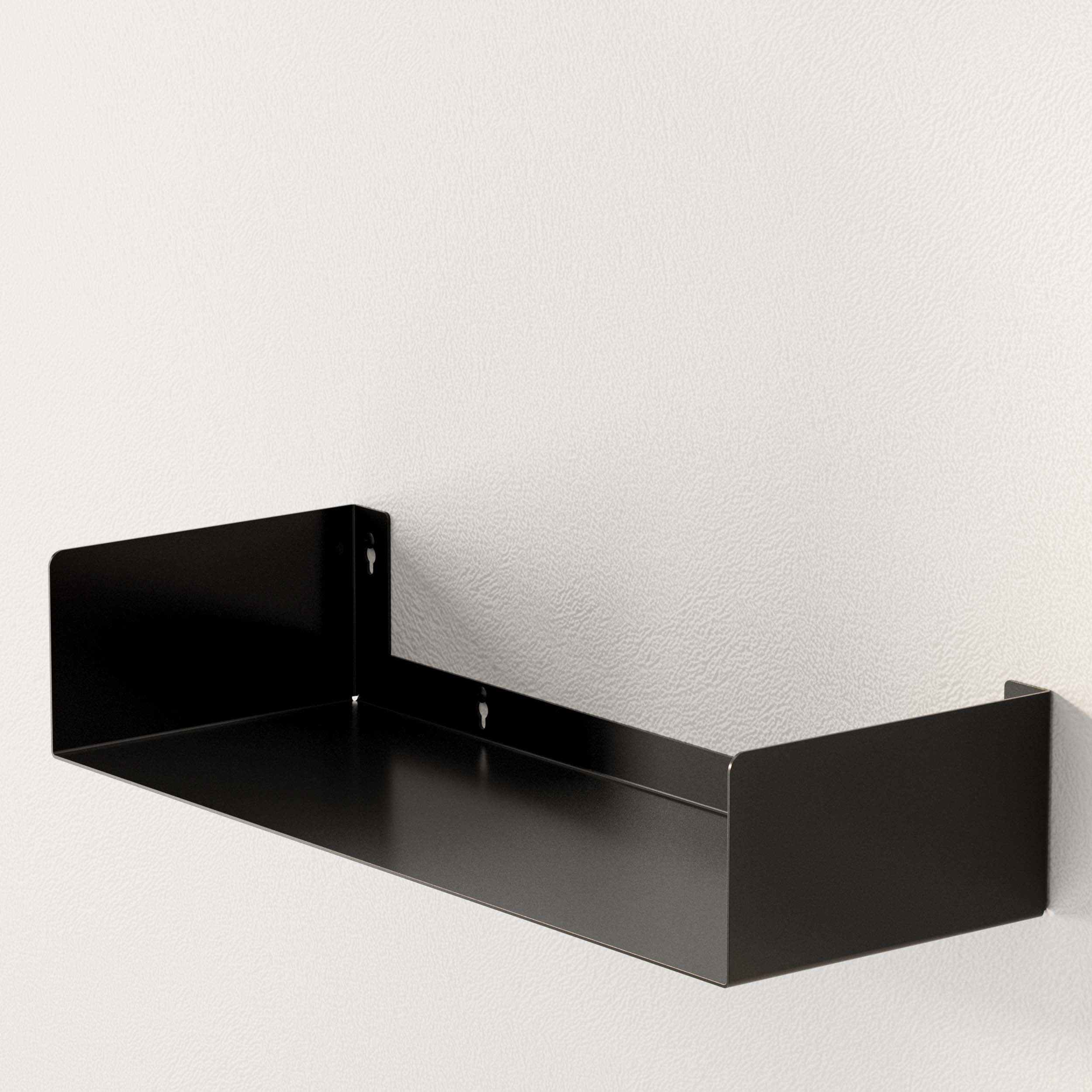 A black metal U-shape wall shelf installed on a white wall. The shelf’s minimalist design blends seamlessly into any interior, providing a stylish storage solution for various items.