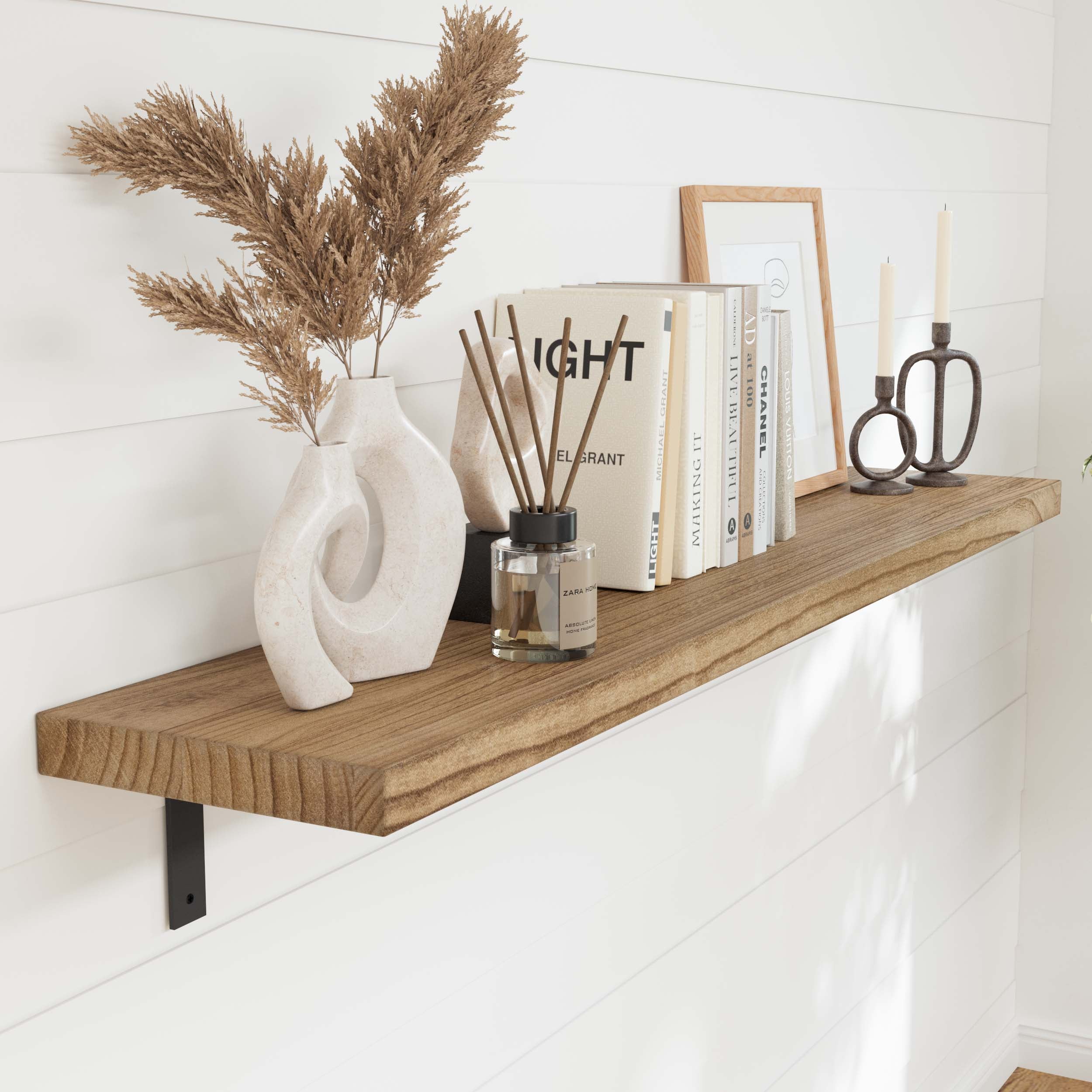 A long display shelf with a smooth, burnt finish. Decorated with books, a modern vase, and diffuser sticks, it highlights the craftsmanship and aesthetic of the paulownia wood.