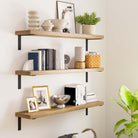 Three floating display shelves decorated with stylish elements like frames, baskets, and books. The space feels cozy with warm wooden textures and minimalist decor.