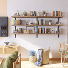 A vibrant wall with three long storage shelves featuring books, plants, and baskets, adding character and utility to a cozy room corner.
