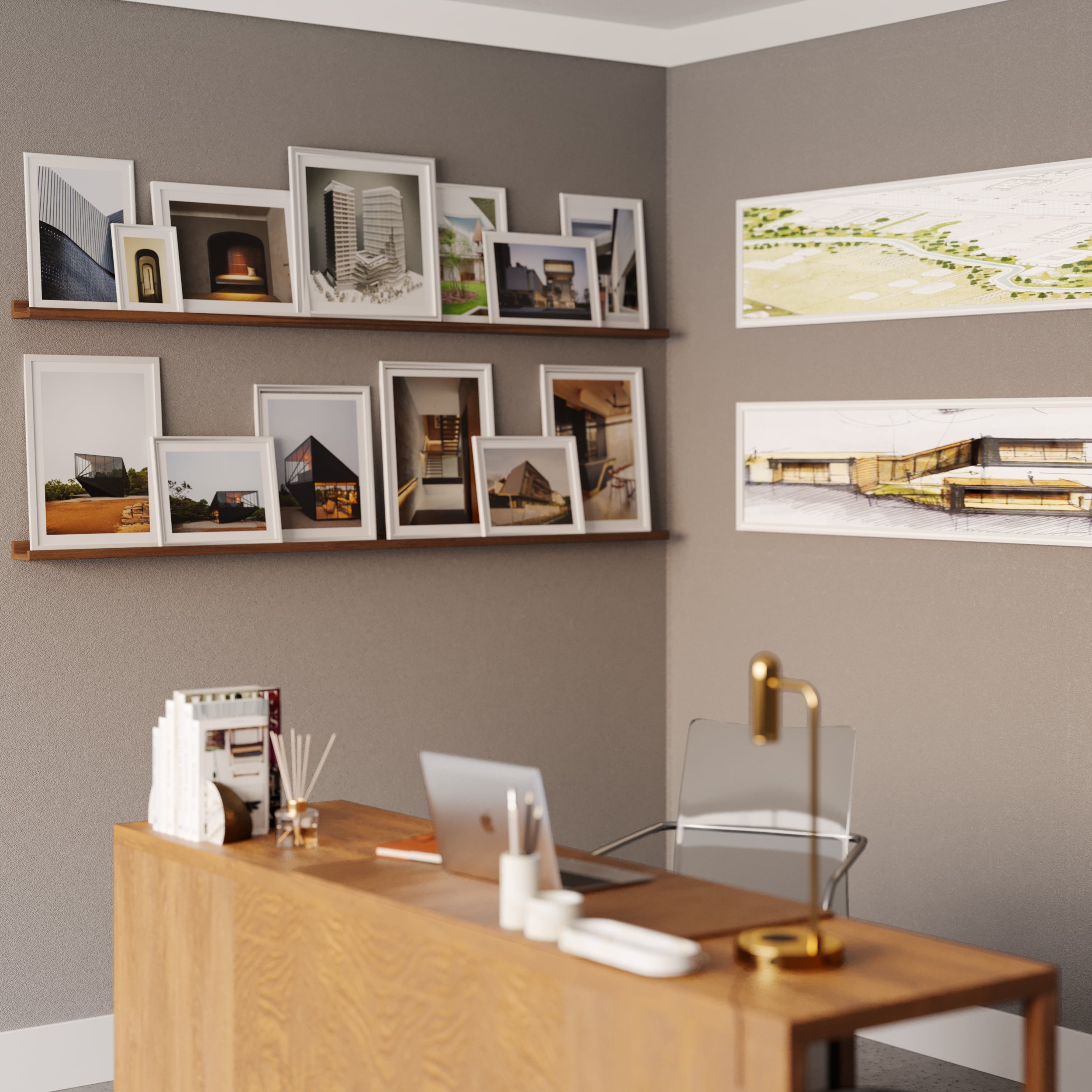 A modern home office with a walnut desk and clear chair, accented by wall shelves above filled with framed architectural photos.