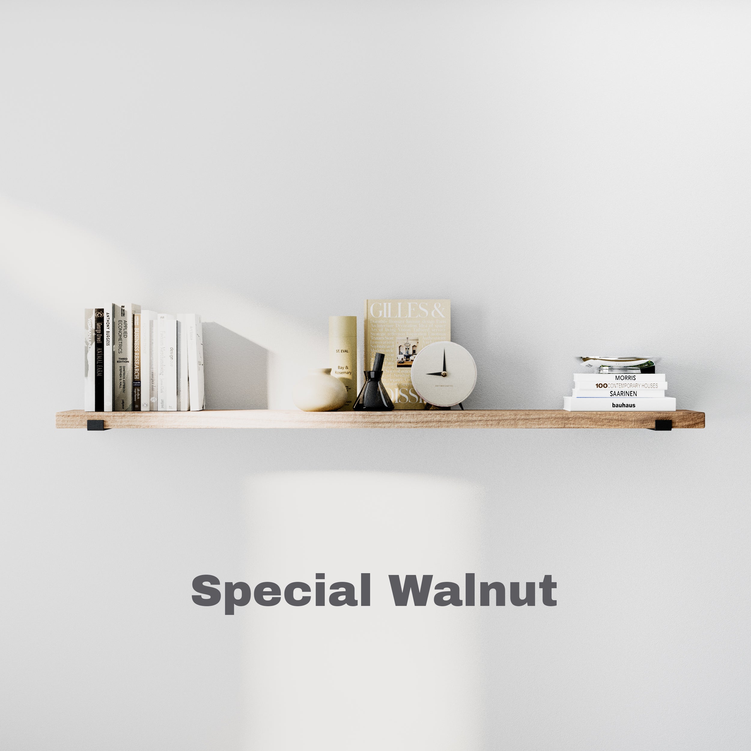 A minimalist 60 inch long floating shelf in special walnut color holding books, a clock, and neutral-toned décor against a light gray wall.