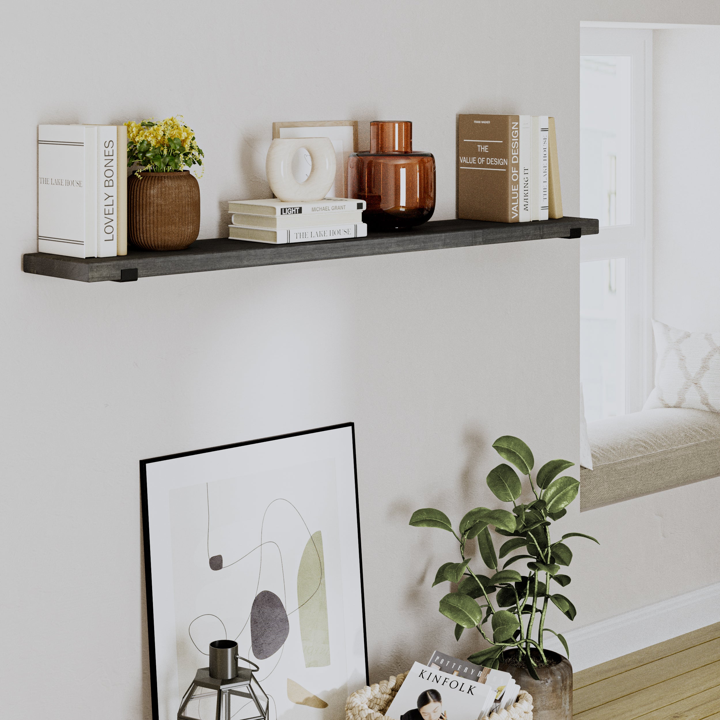 A floating ebony shelf decorated with books, vases, and ornaments against a cozy reading nook with a potted plant below.