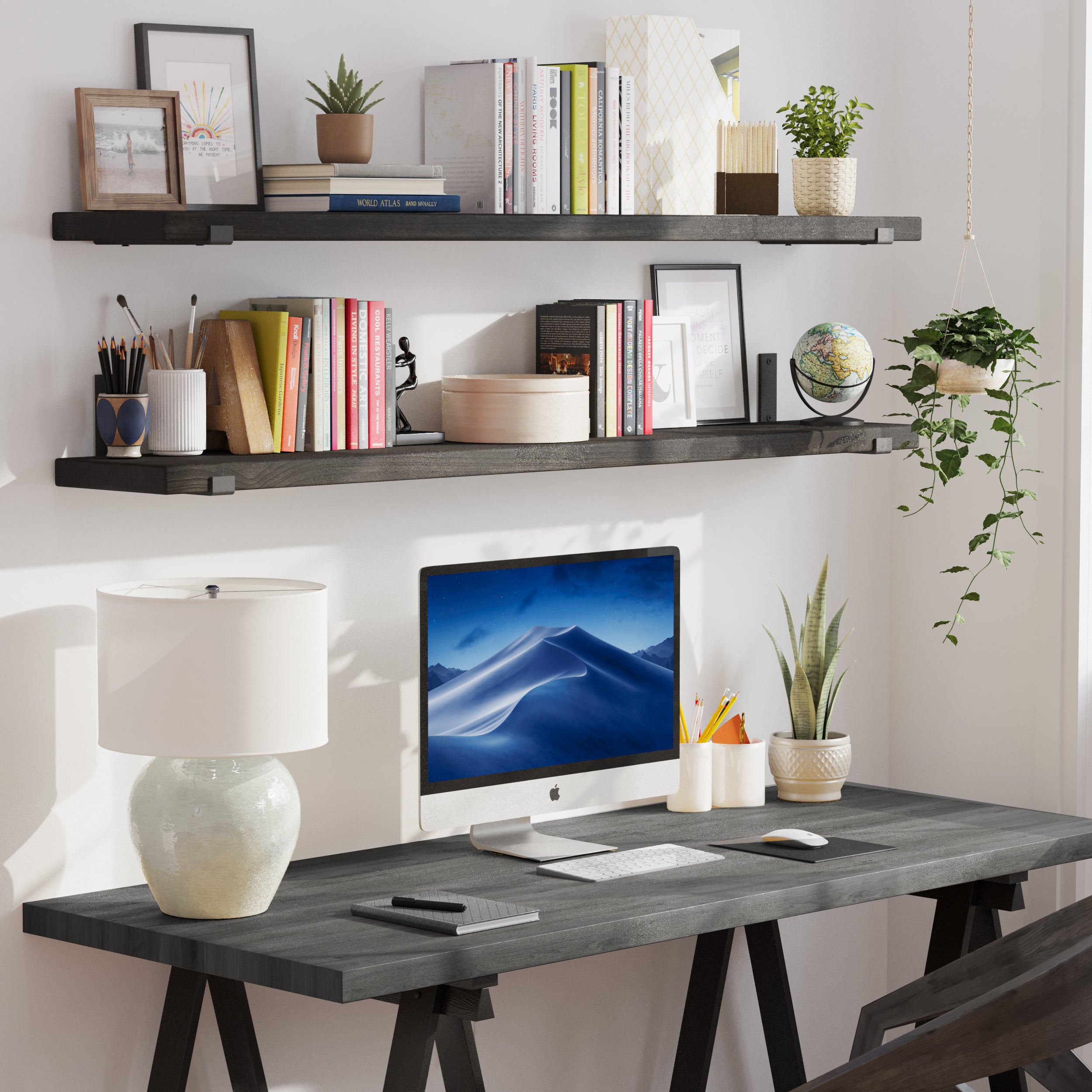 Two wooden office shelves with books and decorative objects above a black desk in a modern home office setup.