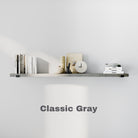 A long floating shelf in "Classic Gray" finish against a white wall. The shelf is minimally styled with books, a clock, and neutral decor. The text "Classic Gray" is displayed below.