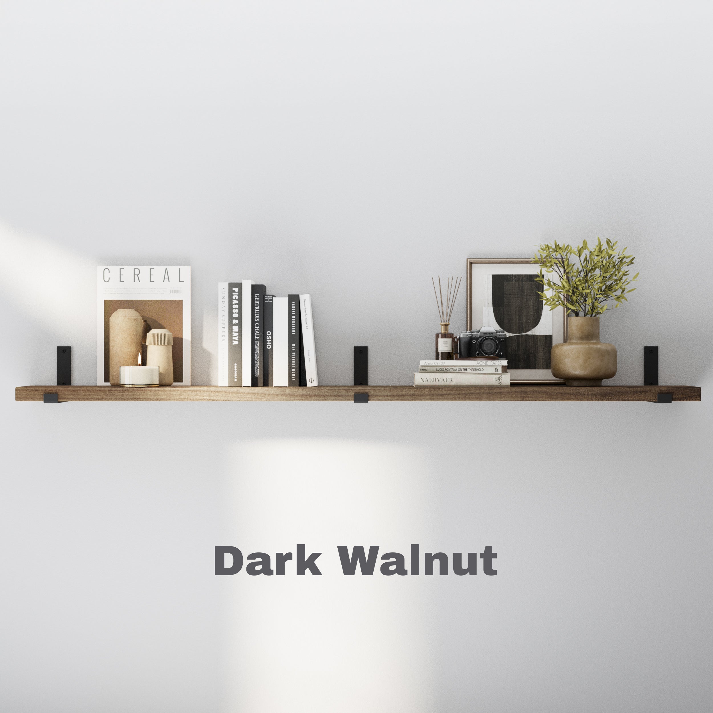 A single floating shelf in a rich Dark Walnut finish, mounted with black brackets and styled with books, ceramics, and a framed print for a modern, minimal look.