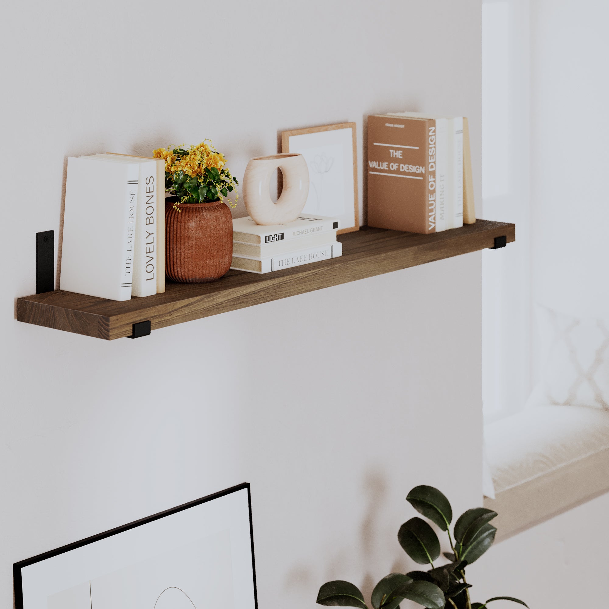 Styled wall decor shelf with books, a vase, and decor. Warm wood tone and black brackets create a modern, cozy look, perfect for living room or bedroom wall décor.