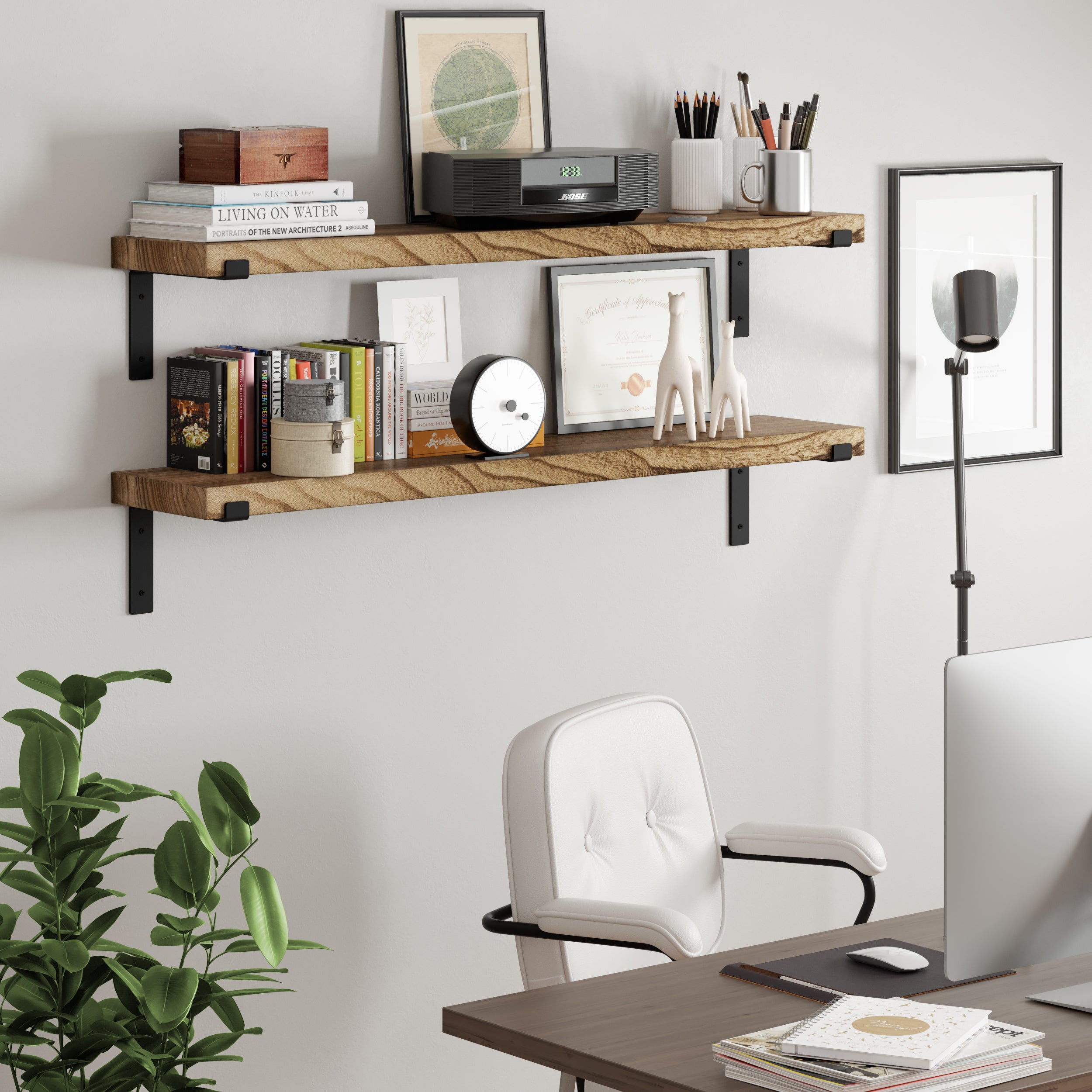 A workspace setup with two wooden office shelves above a desk, filled with books, framed art, a clock, and small decor pieces.