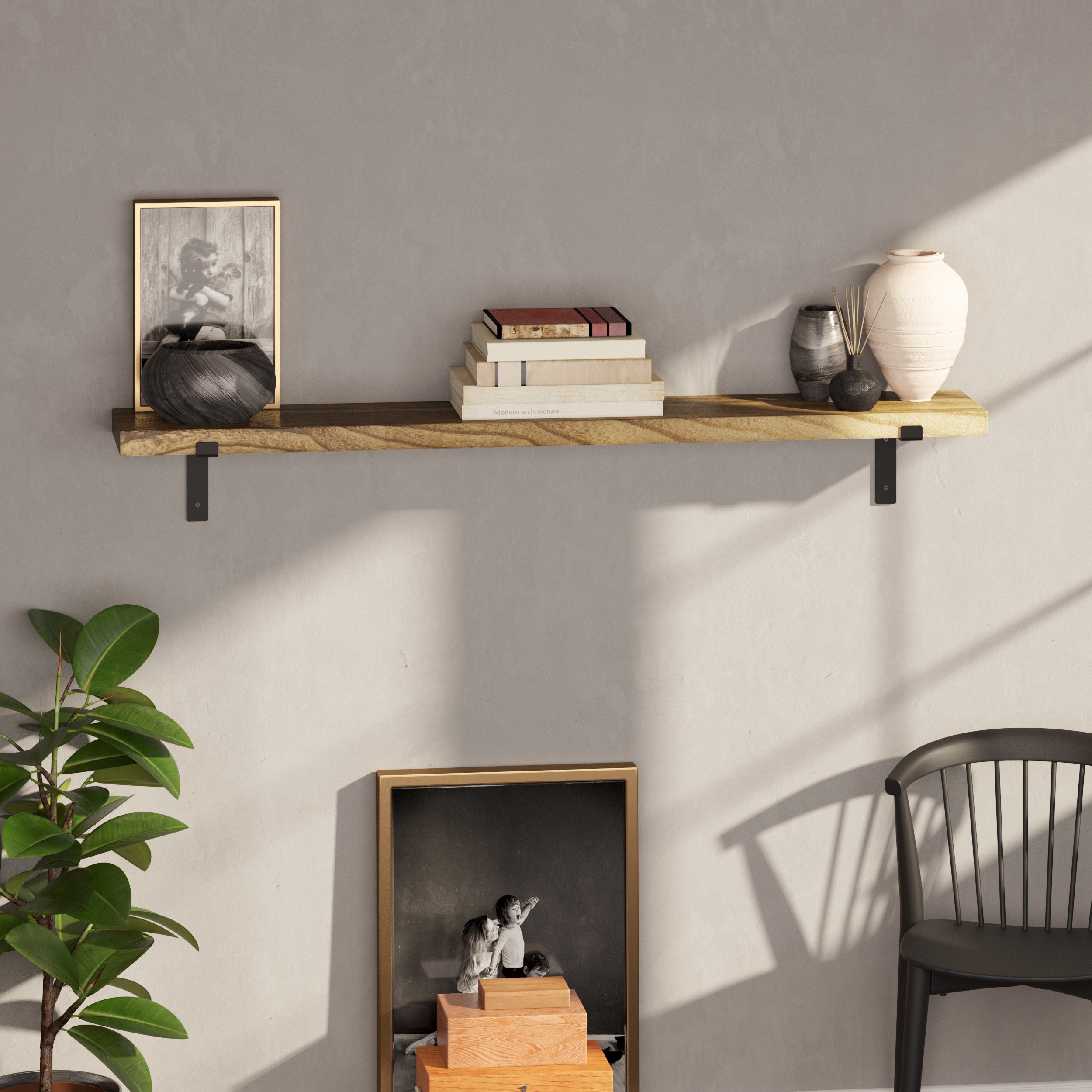 A single wooden shelf for living room decor on a gray wall with books, a framed photo, and ceramic vases.