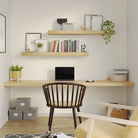 Office workspace featuring two floating shelves above a minimalist desk. Demonstrates practical use for storage and organization in home offices or study areas.