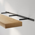 Durable black hidden bracket system. Demonstrates the sturdy metal rail that supports the farmhouse shelf while maintaining a seamless floating appearance.