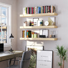 An elegant home office setup with three ultra thick boho shelves in natural finish, organizing stationery, books, framed art, and accessories above a modern desk by the window.