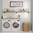 Organized laundry room with a pipe shelf storing detergents, towels, and décor, enhancing utility and style.