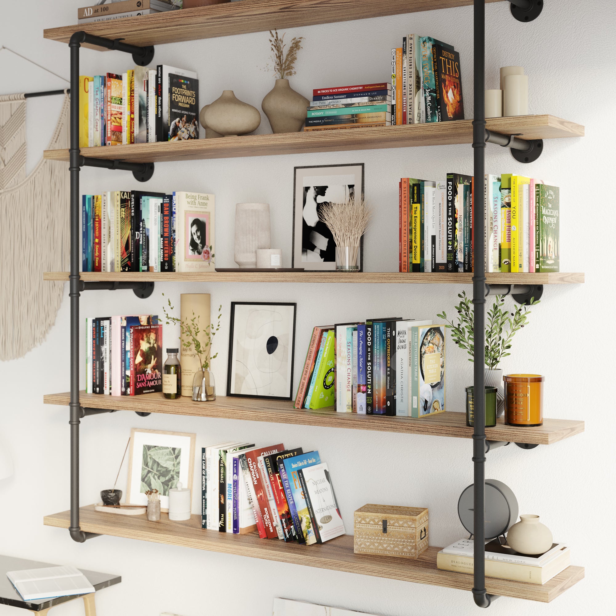 A stylish living room setup with the multi tier floating shelf unit with pipe shelving brackets, filled with books and decorative objects. The wall mounted pipe shelves blend seamlessly with the decor, adding both storage and style.