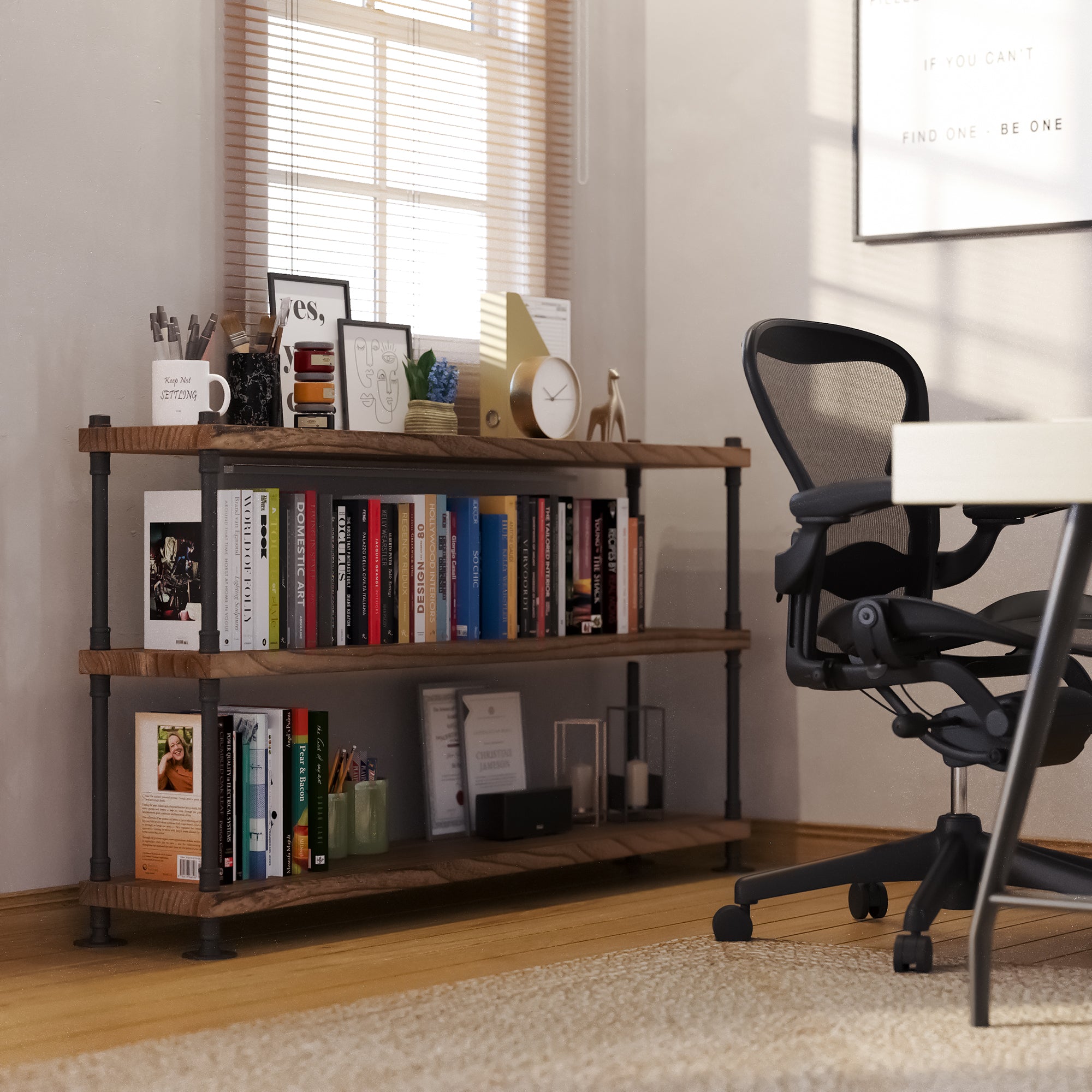 Industrial bookshelf with 60 inch long boards and 3 tier for office decor with books and decor items next to a black office chair in a room with a window.