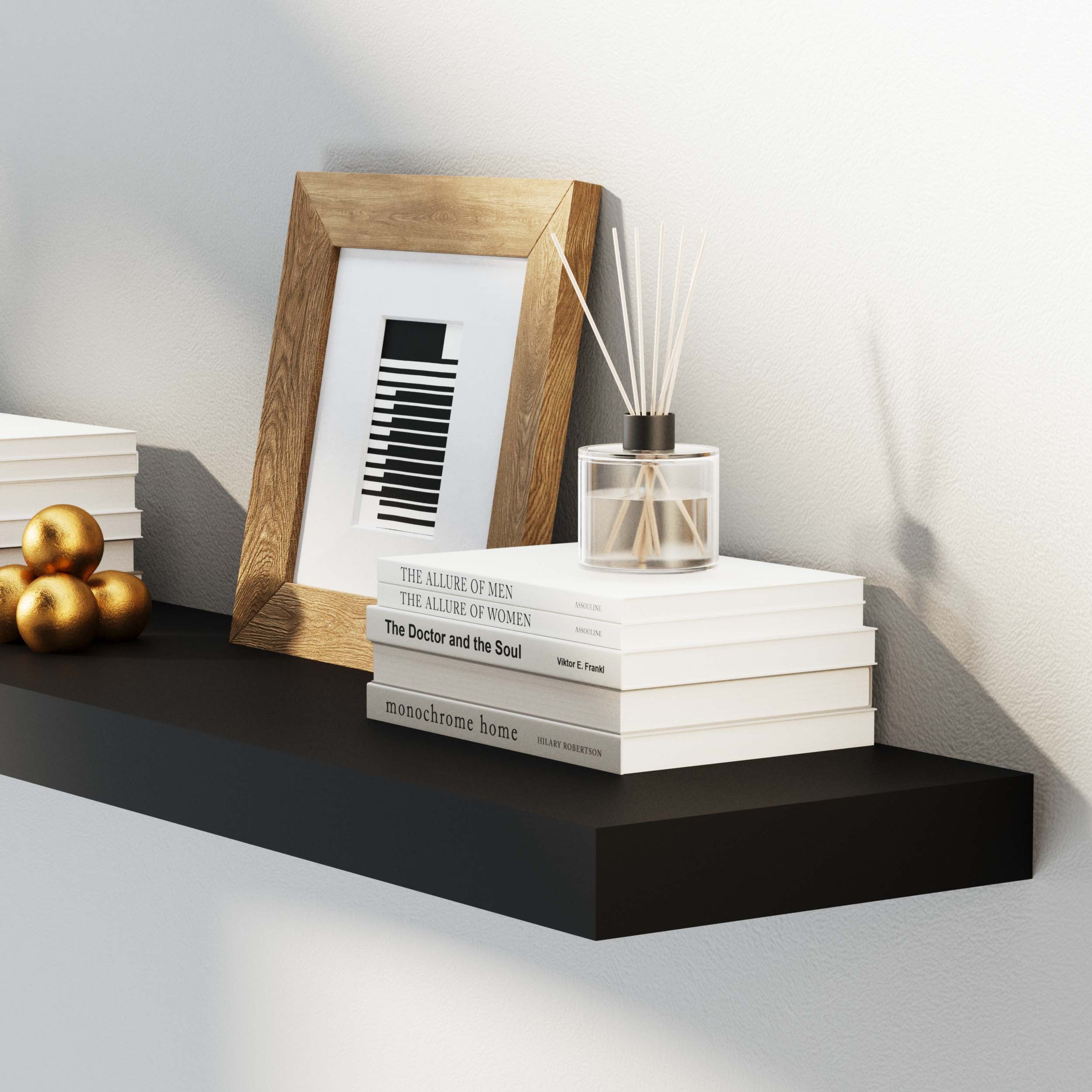 Close-up of a black floating shelf displaying books, a framed photo, and a diffuser, highlighting its sleek, minimalist design suitable for modern décor.