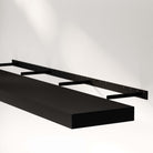 A foating shelf for wall black with an invisible bracket, mounted on the wall, highlighting its sleek design and sturdy brackets.