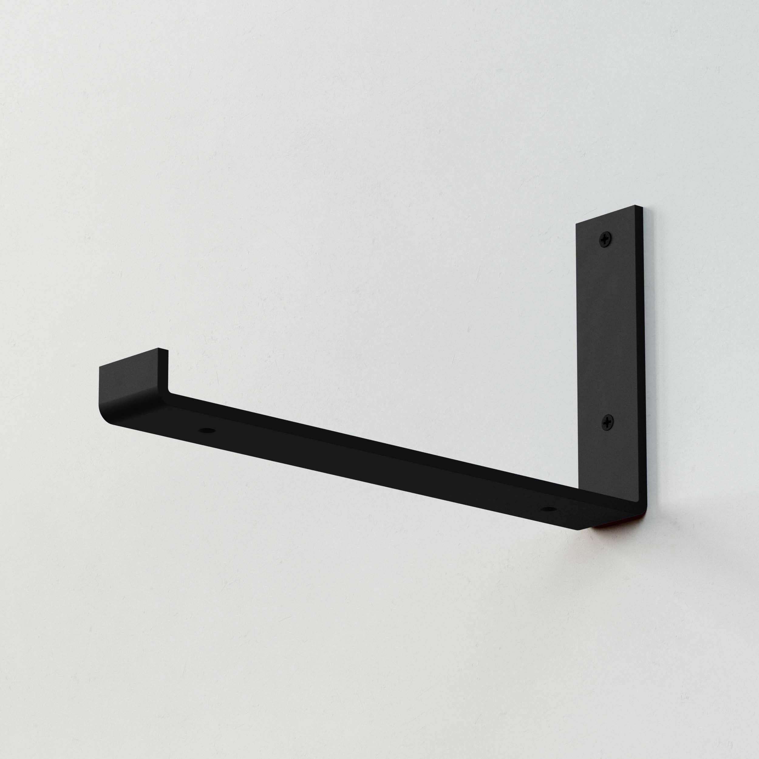 A single black rectangular shelf bracket mounted on a wall.