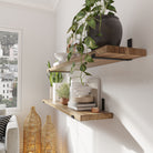 Side view of a living room with wooden shelves and black metal brackets, showing décor elements.