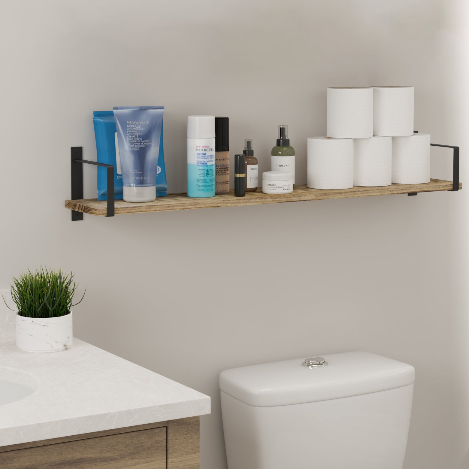 A single floating bathroom shelf installed above a toilet displays essentials like skincare products and toilet paper, providing stylish and practical bathroom organization.