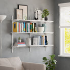 A white wall-mounted floating shelf styled with books and plants in a cozy living space, enhancing home decor and functionality.