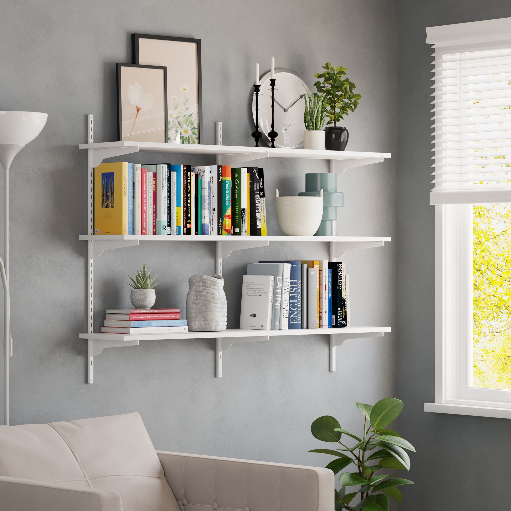 A white wall-mounted floating shelf styled with books and plants in a cozy living space, enhancing home decor and functionality.