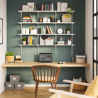 A cozy green wall with a 4-tier white office shelving unit with adjust brackets setup holding books, decor, and greenery. Perfect above a sofa or for home library setups.