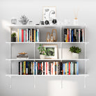 A 4-tier adjustable white wall book shelf filled with colorful books, modern art, and neutral-toned decor. Ideal for minimal and organized home setups.