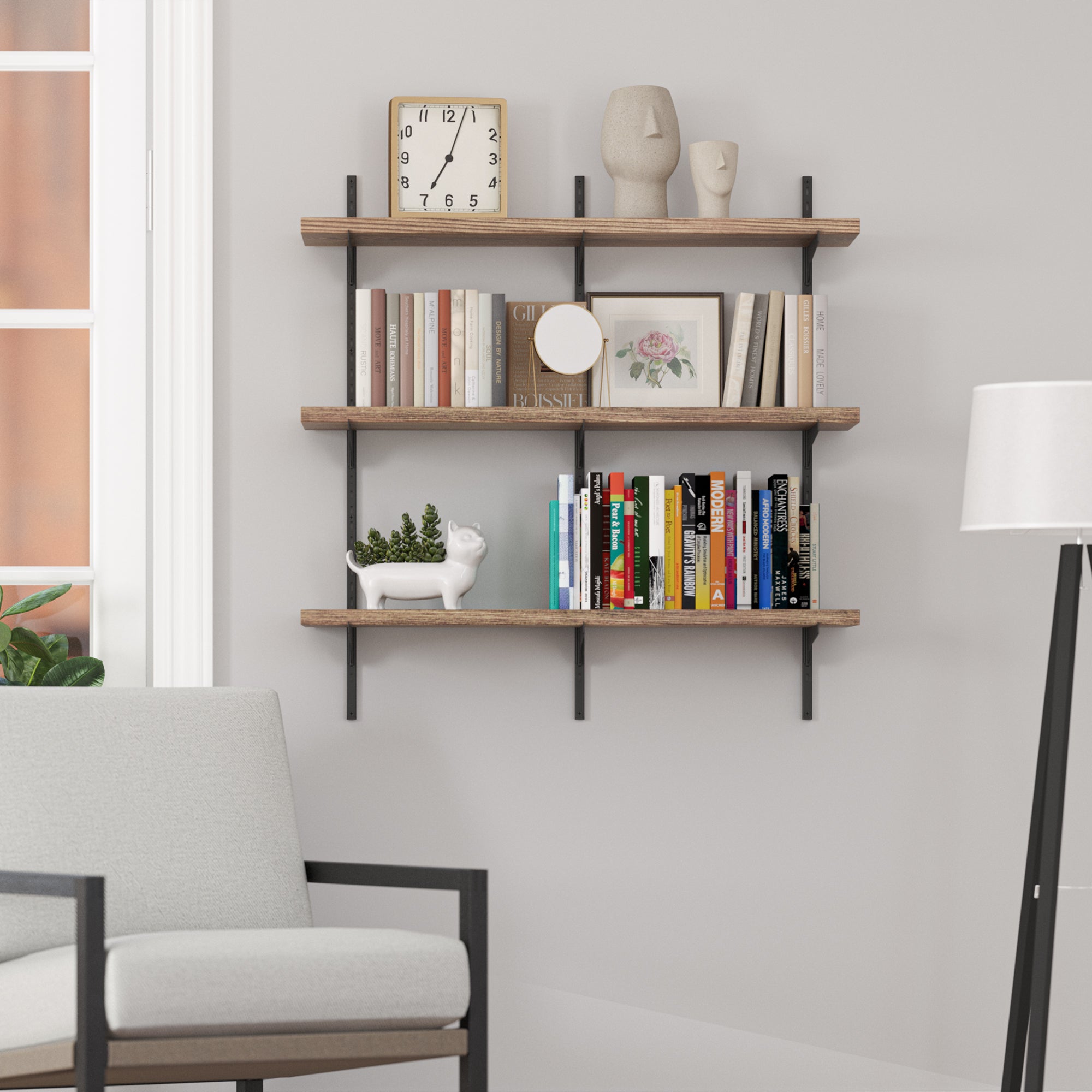 3 tier decorative shelves in a rich burnt finish with black brackets with books and decor items against a light gray wall in a living room setting.