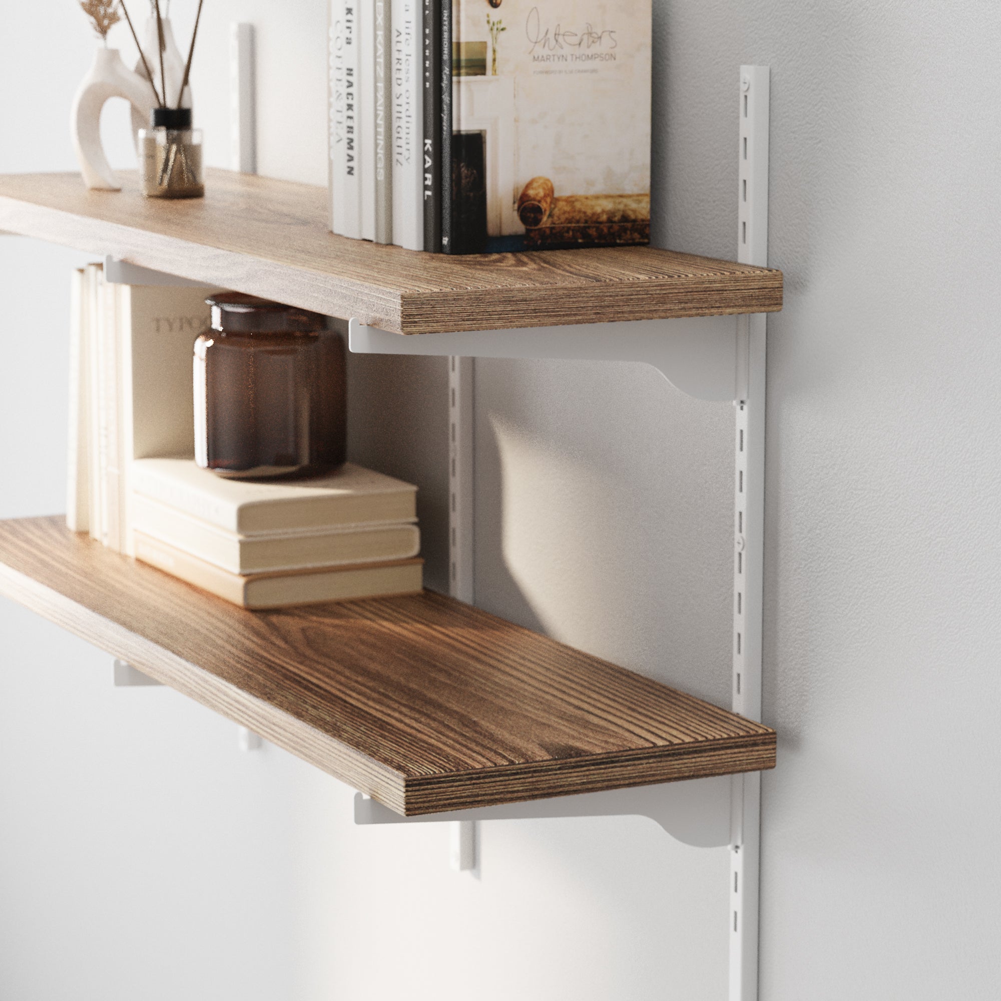 Real wood shelves with adjustable white brackets with decorative items against a white wall