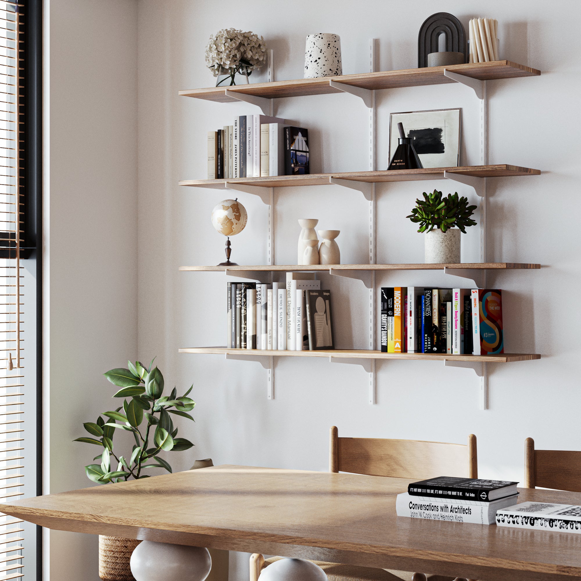 Rustic shelving unit suitable for boho and farmhouse decor with books and decor items above a wooden dining table.