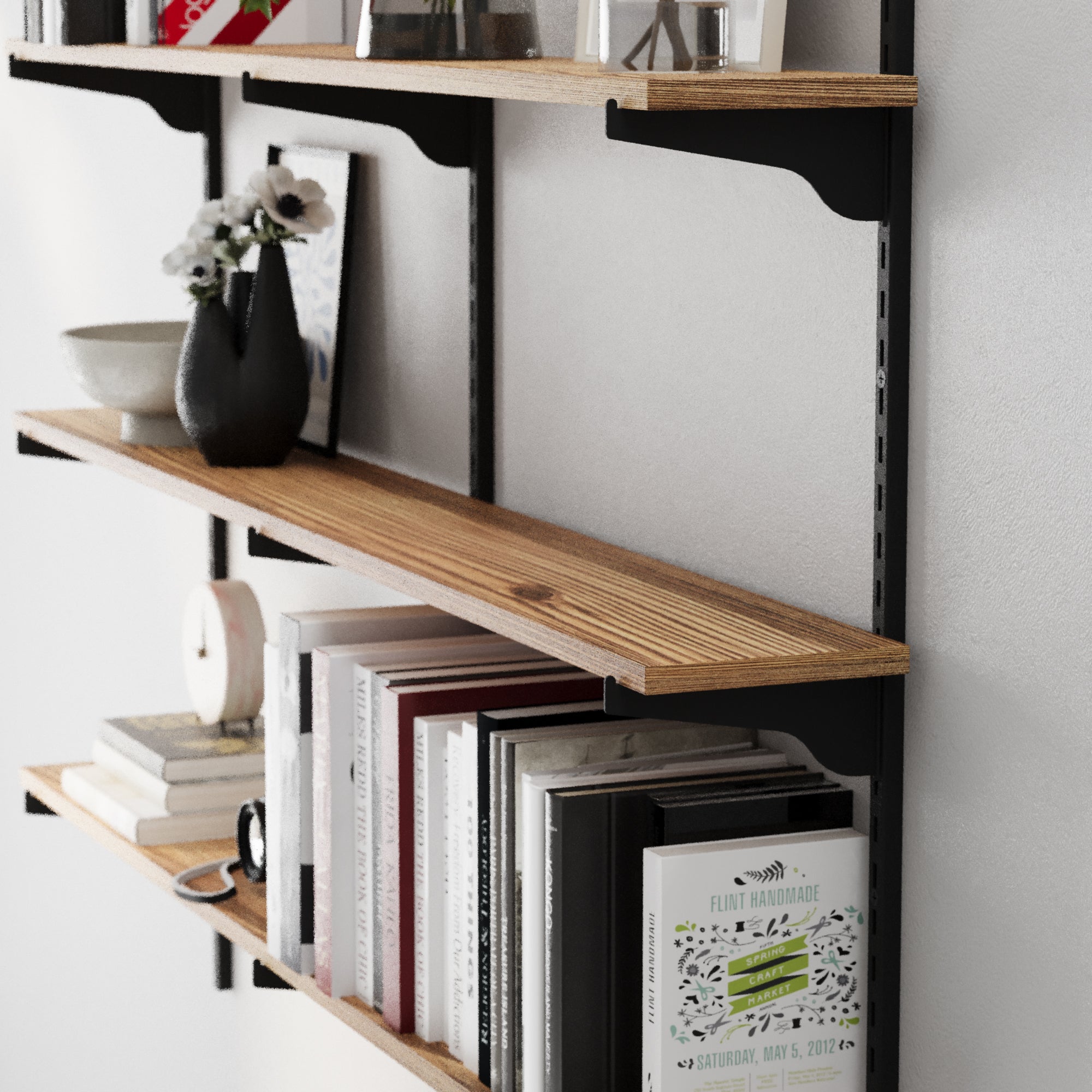 Wooden shelf with books and decorative items against a white wall