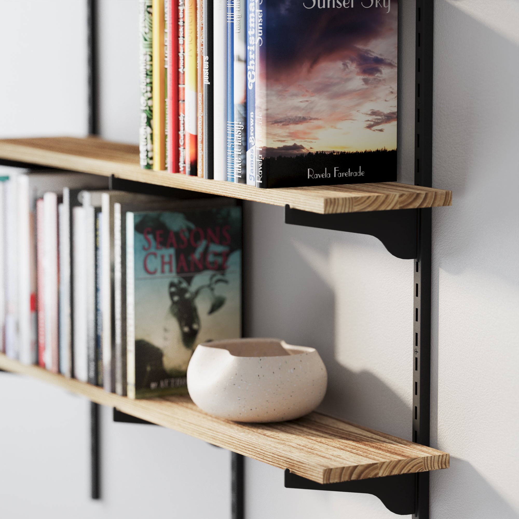 A farmhouse shelf’s wood texture and black brackets, displaying neatly organized books and a ceramic bowl for a natural, minimal aesthetic.