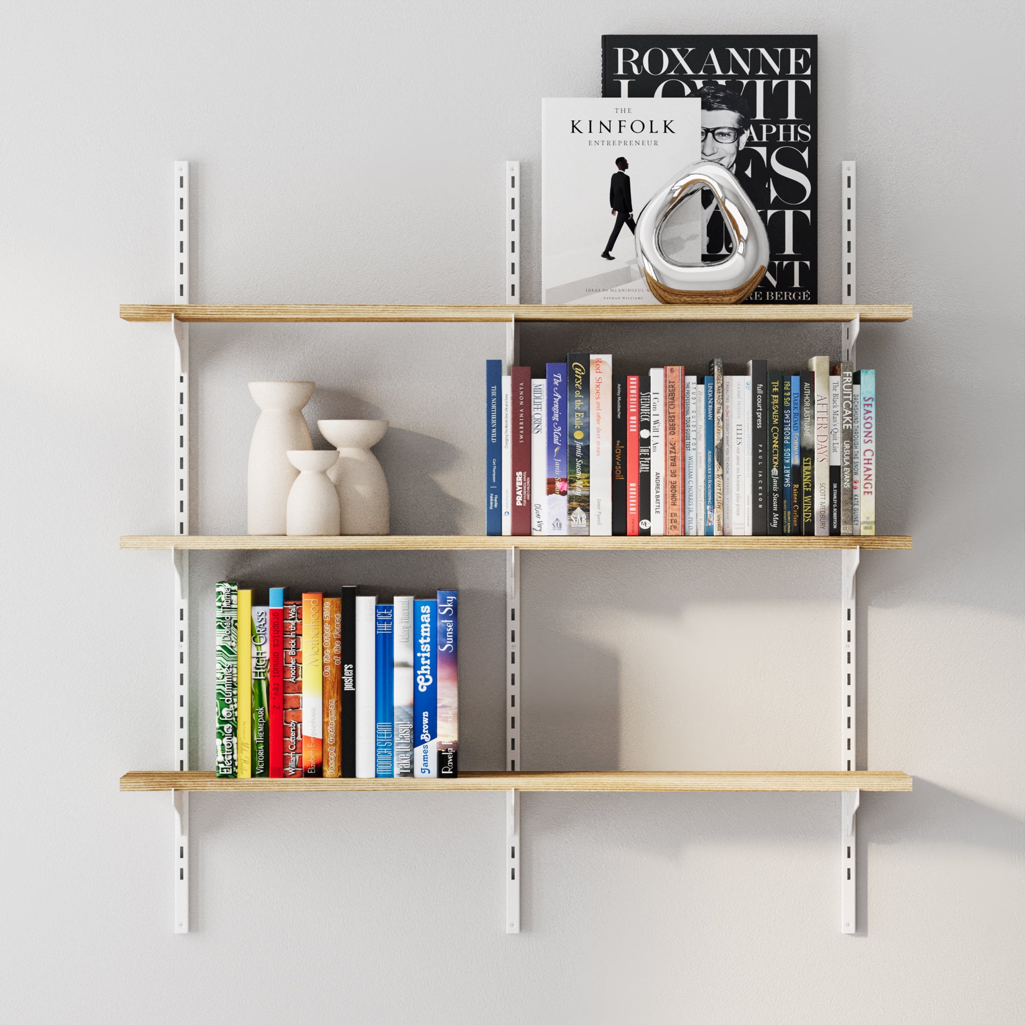 Wall-mounted bookshelf with books and decorative items against a light gray wall