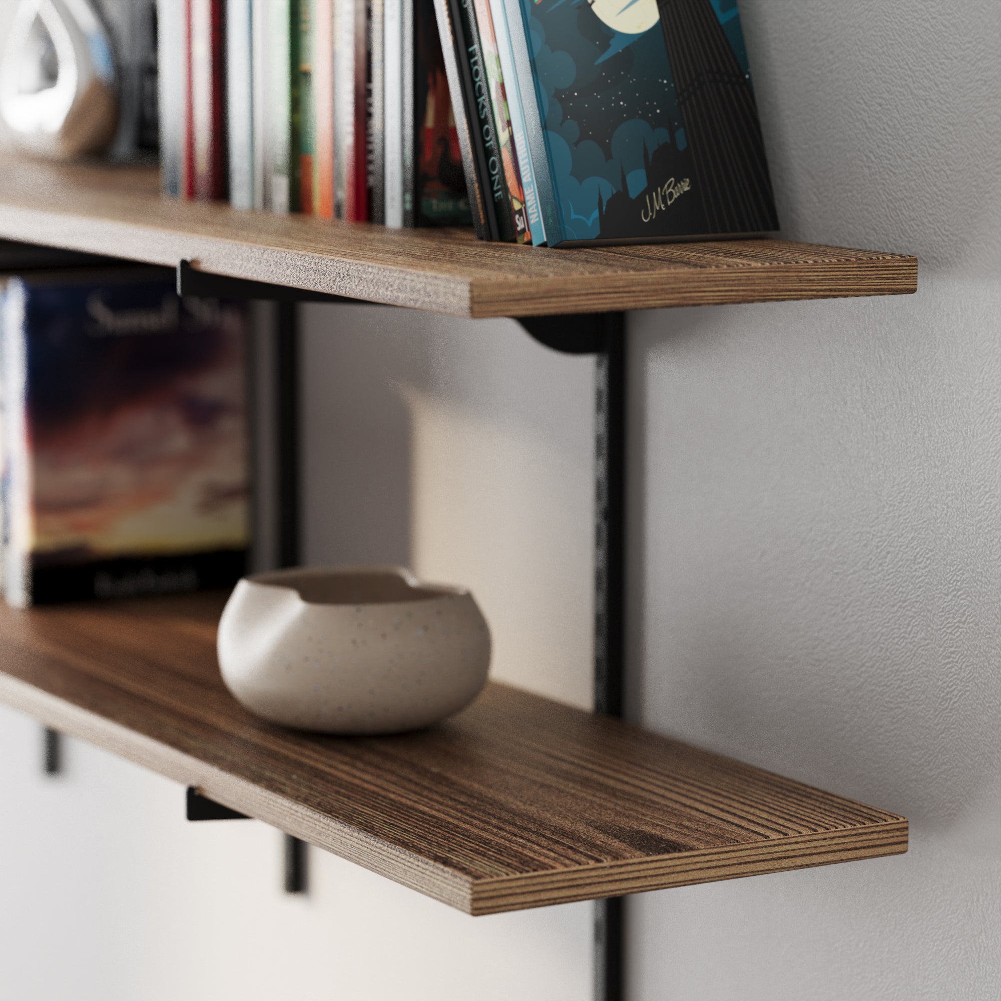 Long floating shelf with adjustable brackets and rails with a ceramic bowl on a plain wall