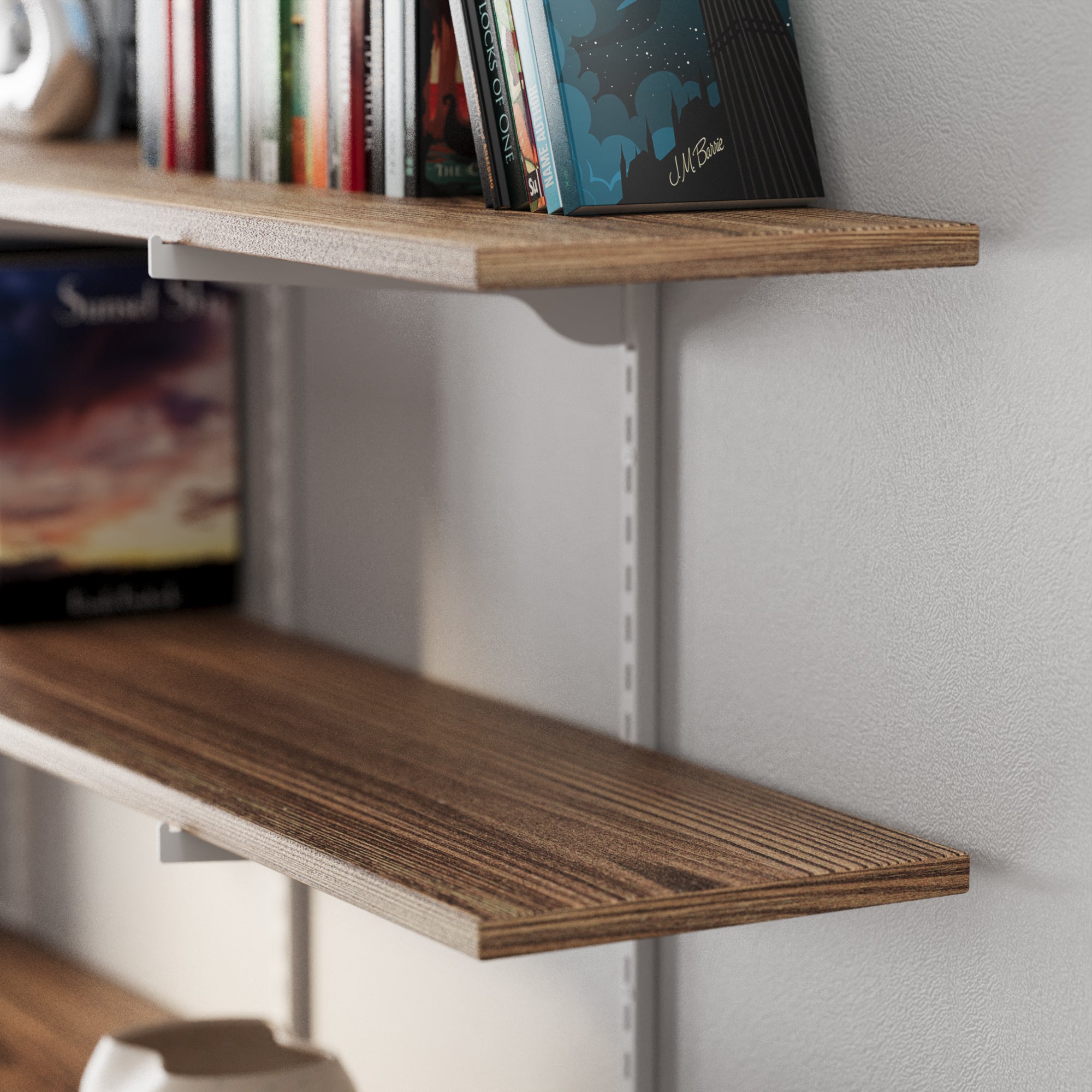 Adjustable shelves with white heavy duty metal brackets on a white wall with books and decorative items.